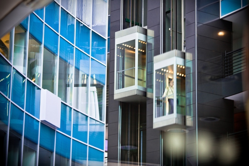 Building with a glass lift carrying people