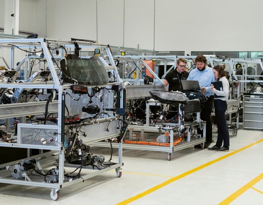 Three engineers looking at a laptop